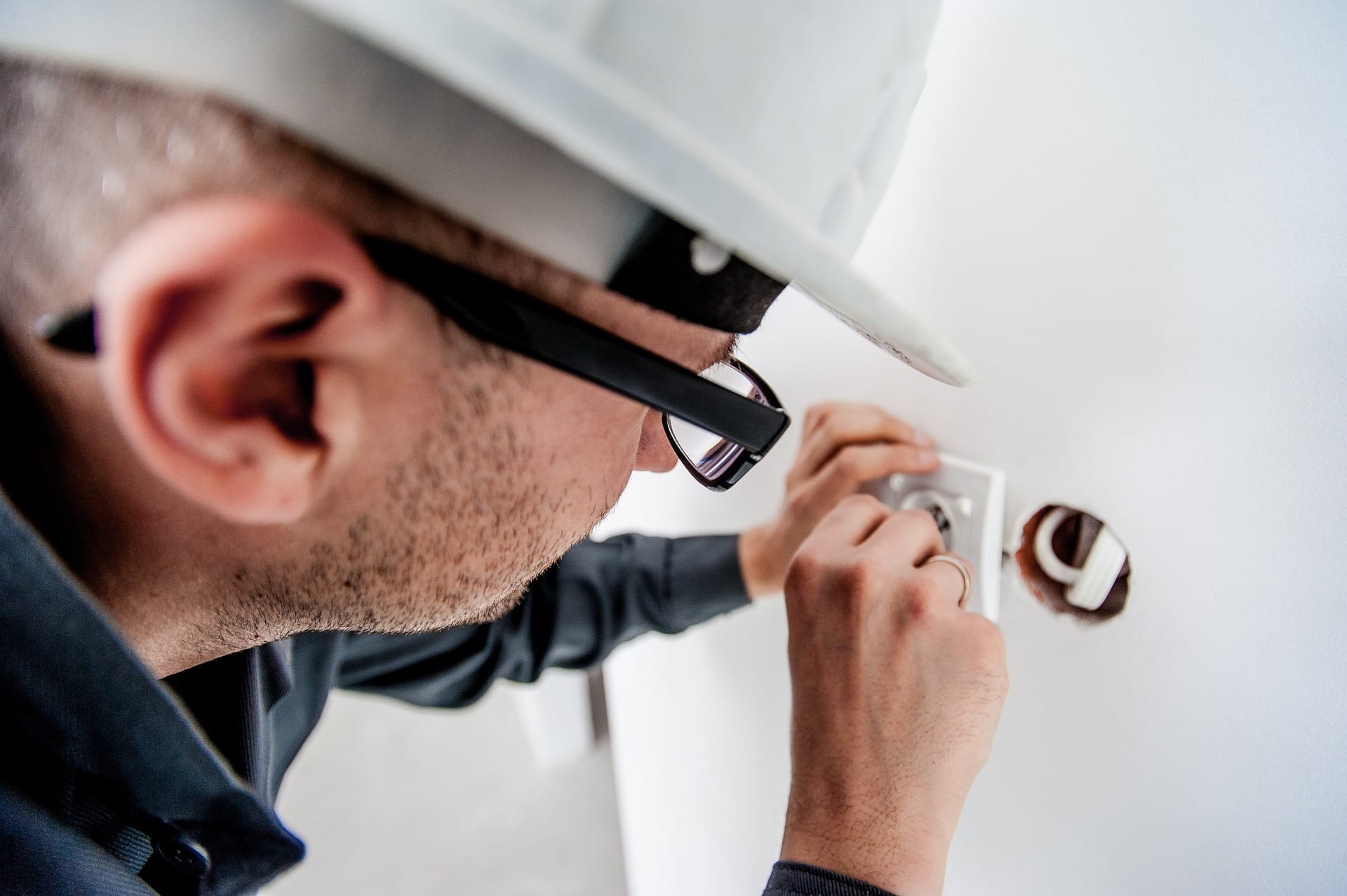 Electrician installing wall socket in a residential home | Electrician Insurance | Hettler Insurance Agency, Lubbock Texas