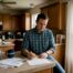 Texas homeowner reviews insurance document at kitchen
