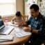 Father and daughter reviewing insurance documents at home