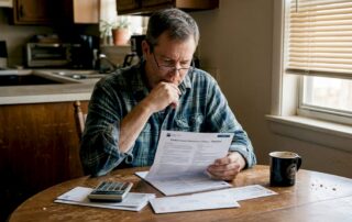 Texas homeowner reading insurance documents at kitchen table