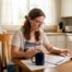 Woman reading Texas auto insurance documents at kitchen table