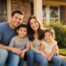 Young Texas family of four sits smiling on the front porch of their Lubbock home at golden hour after reviewing life insurance coverage.